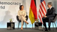 Außenministerin Annalena Baerbock diskutiert mit ihrem US-Amtskollegen Antony Blinken auf einem Podium