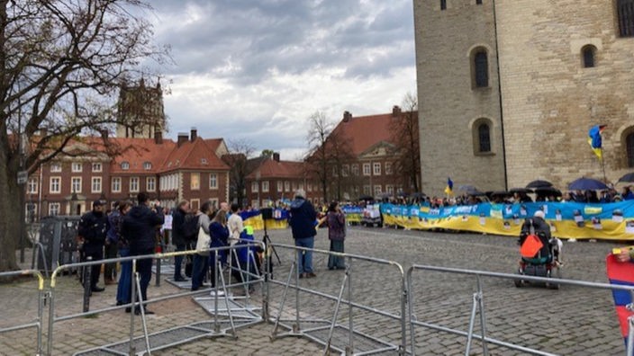 Vorm Schlossplatz haben sich Demonstrierende mit Transparenten versammelt