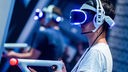 Ein Besucher der Gamescom 2018 probiert an einem Stand ein Videospiel mit einer VR-Brille aus