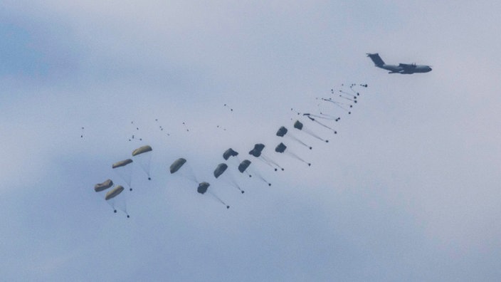 Aus einem Flugzeug segeln Hilfsgüter an Fallschirmen in den Gaza-Streifen.