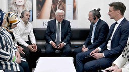 Bundespräsident Frank-Walter Steinmeier und NRW-Ministerpräsident Hendrik Wüst (CDU) sprechen mit Menschen in der Kölner Keupstraße