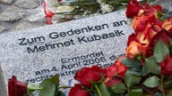 Rote Rosen liegen in Dortmund auf einem Gedenkstein für den Ermordeten
