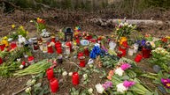 Kerzen, Blumen und einige Kuscheltiere liegen an der Stelle im Wald, an der die Menschen in Freudenberg Abschied von Luise nehmen