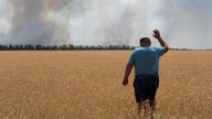 Ein Landwirt reagiert, als er auf sein brennendes Feld blickt, verursacht durch die Kämpfe an der Frontlinie in der Region Dnipropetrowsk. 