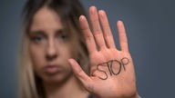 Das Wort "Stopp" auf der Handfläche einer Frau