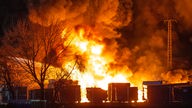 01.01.2023, Nordrhein-Westfalen, Düsseldorf: Flammen schlagen aus einer Lagerhalle