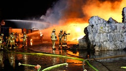 01.01.2023, Nordrhein-Westfalen, Düsseldorf: Flammen schlagen aus einer Lagerhalle