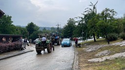 Nach dem Unwetter in Dörentrup schaufeln Anwohner den Schlamm beiseite und die Landwirte aus der Region unterstützen mit ihren Fahrzeugen