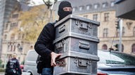 Duisburg: Beamte tragen Metallkisten mit Goldbarren und Bargeld