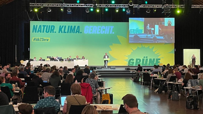 Aufnahme vom Landesparteitag der Grünen in Münster, ein Redner auf der Bühne vor einem Publikum