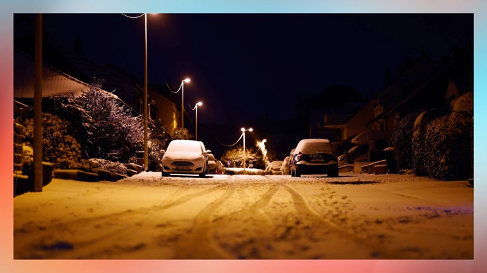 Eine Straße mit Schnee bedeckte Straße mit prakenden Autos an den Seiten