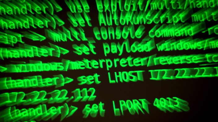 Buchstaben und Zahlen leuchten auf einem Bildschirm, auf dem ein Hacker-Programm geöffnet ist. 