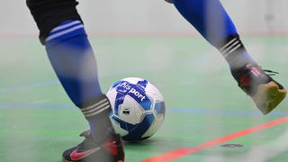 Eine Person spielt Fußball in einer Halle