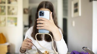 Smartphone wird während dem Essen benutzt