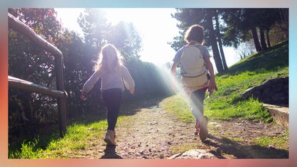 Zwei Mädchen wandern bei sonnigem Herbstwetter.