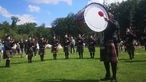 Menschen machen Musik auf einer großen Wiese bei den Highland Games in Lemgo