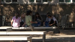 Schüler an einer Neusser Gesamtschule lernen bei großer Hitze im Schatten auf dem Schulhof