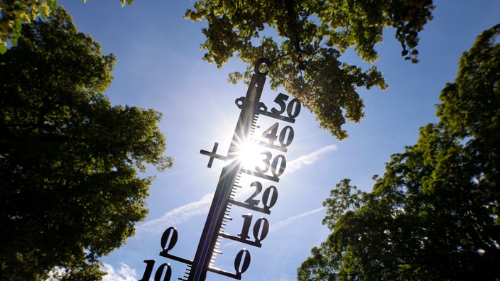 Ein Thermometer, das über 30 Grad Celsius anzeigt vor einem sommerlichen Himmel
