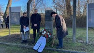 Vor einem Denkmal wird ein Blumenkranz bei der Gedenkveranstaltung im KZ Buchenwald Außenlager Witten Annen abgelegt