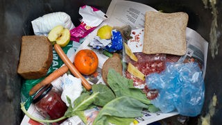 Lebensmittel liegen in einer Mülltonne
