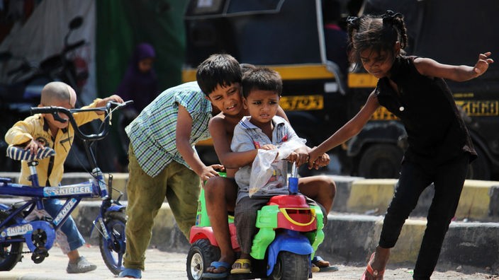 Kinder spielen auf einer Straße in Mumbai