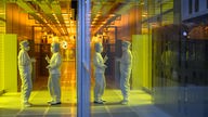 Mitarbeiterinnen des Chipkonzerns Infineon stehen im Reinraum der Chipfabrik