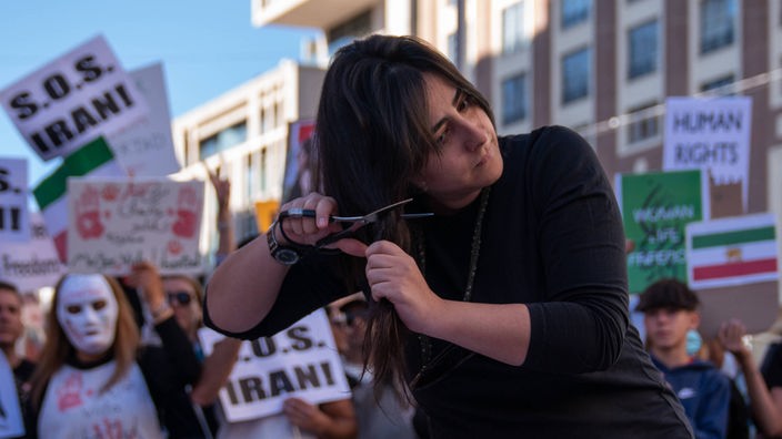 Eine Frau, die sich während der Demonstration in Madrid die Haare abschneidet.