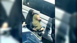 Die Sittenpolizei im Iran fürht Frau eine Frau zu einem Bus, in den sie wenig später hineingedrückt wird
