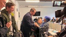 Chef der NRW-Staatskanzlei Nathanael Liminski schüttelt die Hand einer Frau in einer Moschee in Bochum 