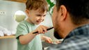 Junge putzt Zähne des Vaters - Symbolbild