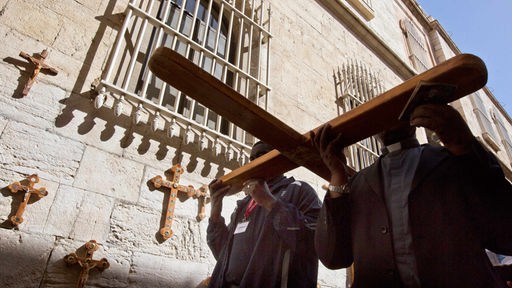 Katholiken tragen ein Holzkreuz durch die Via Dolorosa in Jerusalem am Karfreitag