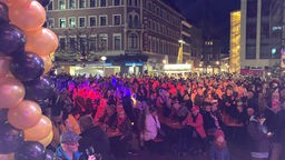Menschen versammeln sich abends zum Karnevalsauftakt in der Aachener Innenstadt