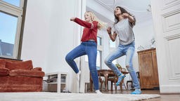 Zwei Mädchen tanzen im Wohnzimmer