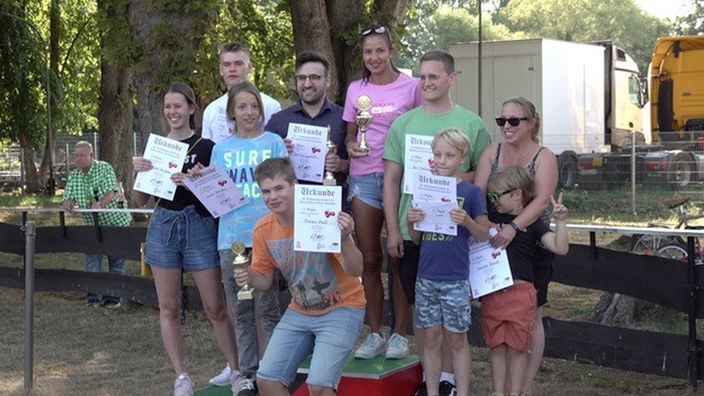 Die Sieger und Teilnehmer der Weltmeisterschaft posieren mit Trophäen und Urkunden