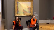 Klimaaktivisten nachdem sie ein Gemälde von Claude Monet mit Kartoffelbrei beworfen haben