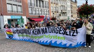 Jugendliche ziehen mit einem großen Banner beim Globalen Klimastreik durch die Straßen