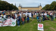 Jugendliche demonstrieren auf einer Wiese in Bonn