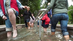 Kinder und Mütter beim Wassertreten im Kurpark