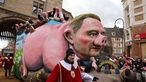 Ein Motivwagen, der Bundesfinanzminister Christian Lindner als Sparschwein zeigen soll, fährt im Rosenmontagsumzug mit