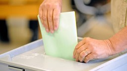 Wählerin wirft Stimmzettel in Urne