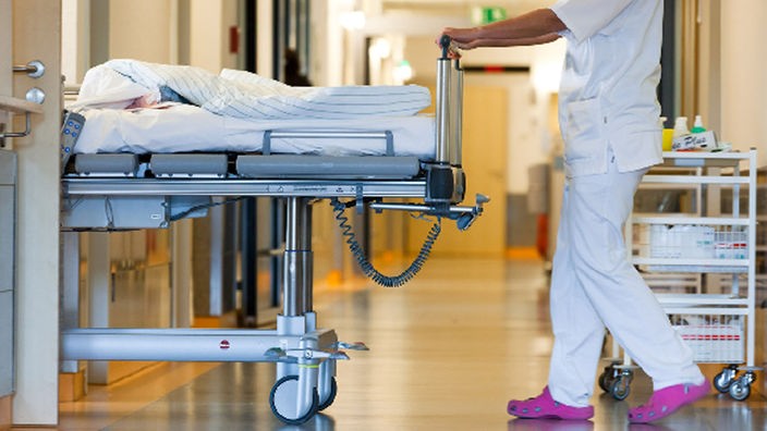 Krankenschwester schiebt Krankenbett