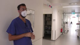Krankenpfleger Adamah steht auf dem Flur seiner Station.