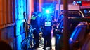 Krefeld: Polizisten stehen auf einem Gehweg neben dem Toten. In der Krefelder Innenstadt ist am Montagabend ein Mann auf offener Straße erschossen worden. 