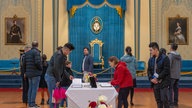 Members of the public write congratulatory messages for Their Majesties King Charles III and Queen Camilla in a commemorative book at Government House on May 06, 2023 in Melbourne, Australia. 