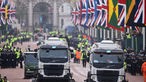 Metropolitan Police officers line the streets as street sweeping vehicles clean The Mall ahead of the Coronation of King Charles III and Queen Camilla