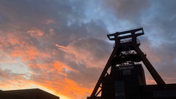 Förderturm der Zeche Zollverein vor einem malerisch aussehenden Himmel