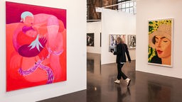 Kunstmesse Art in Düsseldorf: Frau geht durch eine Ausstellung