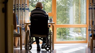 Mann im Rollstuhl alleine im Pflegeheim