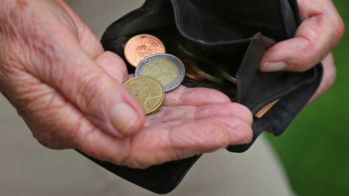 Symbolbild Altersarmut: Seniorin holt wenige Euromünzen aus einem Geldbeutel