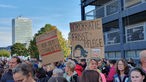 Menschen mit bunten Plakaten demonstrieren vor dem Landtag in Düsseldorf, auf einem steht: "Bürokratie frisst Pflege"